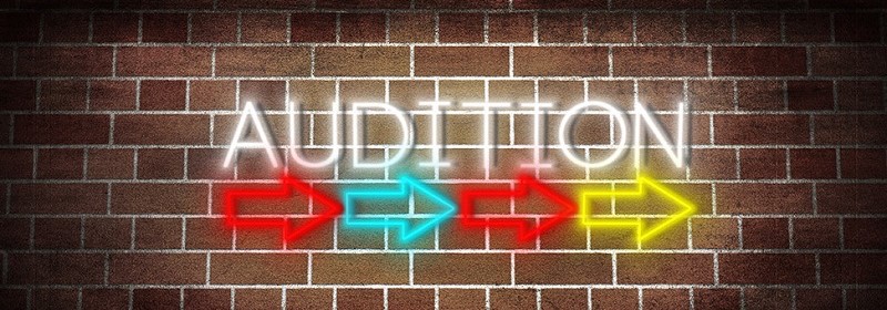 multicolored audition monologues sign on a orange brick wall