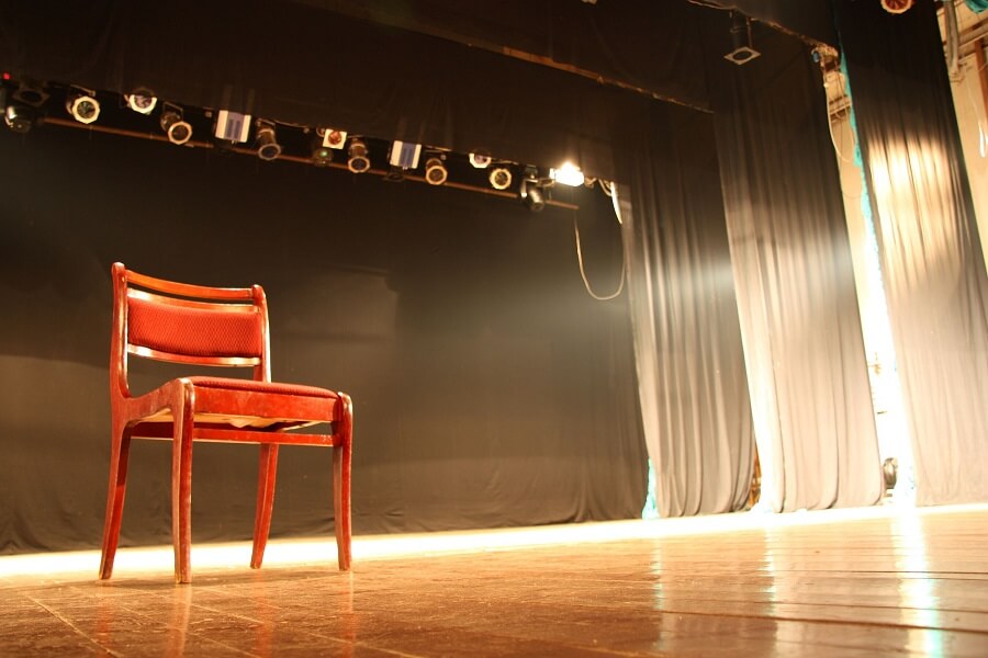 chair in the middle of a stage prepared for monologues