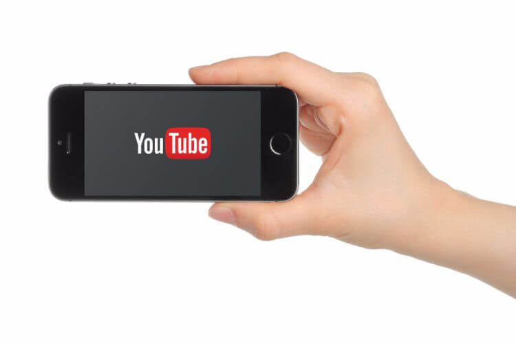 how to become famous on YouTube hand holding a smartphone with the YouTube logo