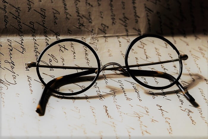 Pair of round glasses with black frame on a paper
