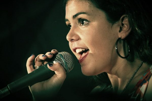 woman singing against black background